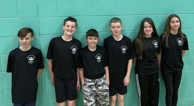 Six students from Kirkintilloch high school wearing branded t-shirts